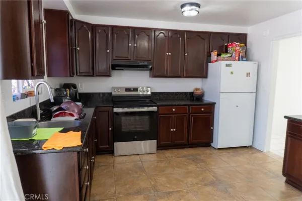 a kitchen with a refrigerator and a stove top oven