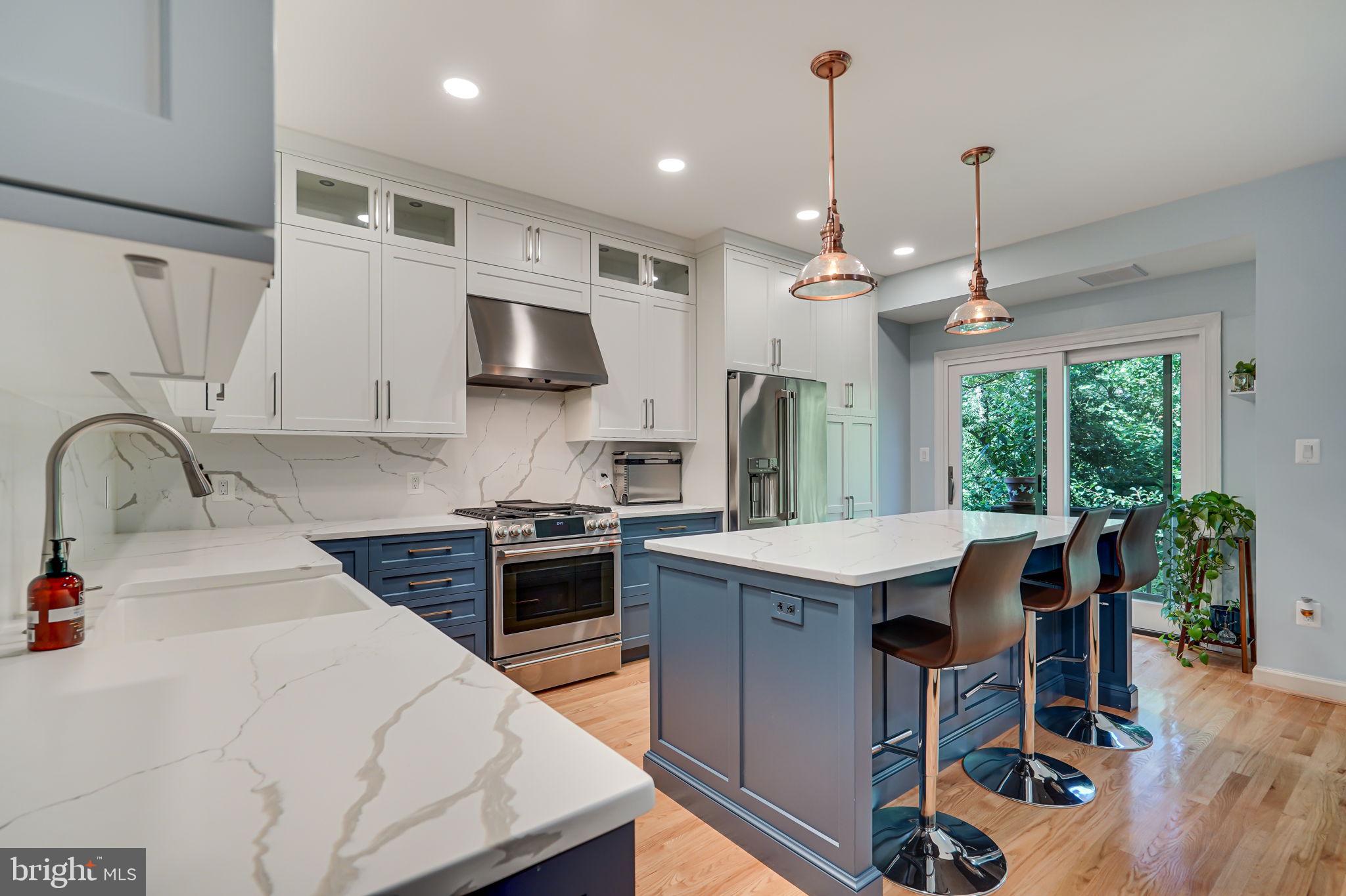 150 Rees Place Falls Church, VA 22046 - Photo 12 of 47 a kitchen with stainless steel appliances kitchen island granite countertop a stove a sink a refrigerator and a wooden cabinets