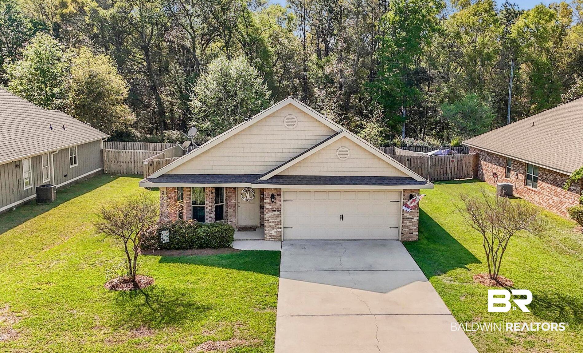22043 Garland Loop Silverhill, AL 36576 - Photo 1 of 41 Craftsman-style house with brick siding, a shingled roof, driveway, a garage, and view of wooded area