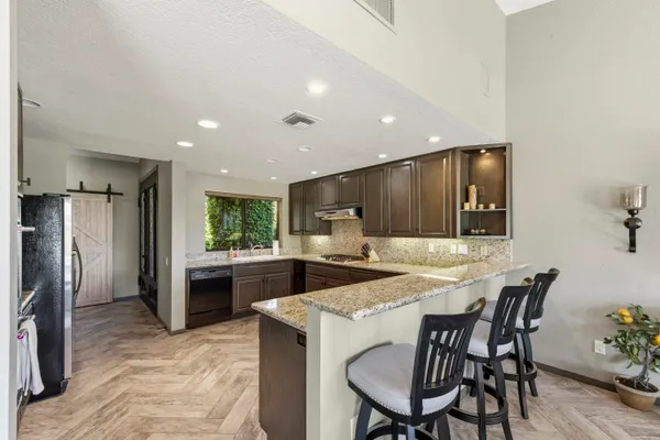 a kitchen with a dining table chairs and refrigerator