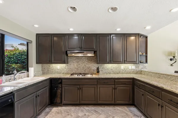 a kitchen with kitchen island granite countertop stainless steel appliances a sink stove and cabinets
