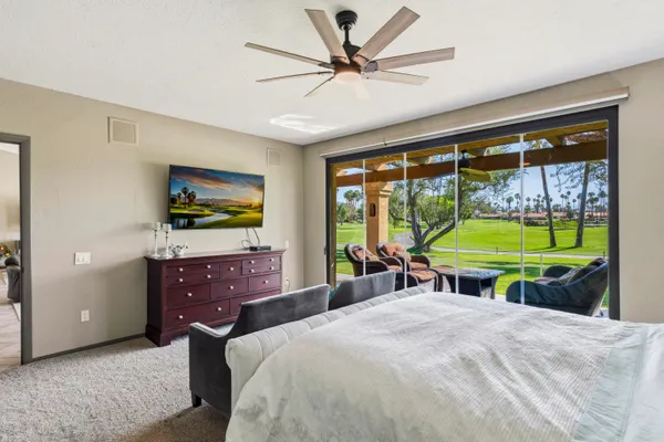 a bedroom with a bed and a flat tv screen on dresser