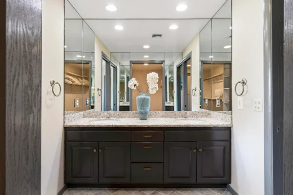 a bathroom with a granite countertop sink double vanity and a mirror