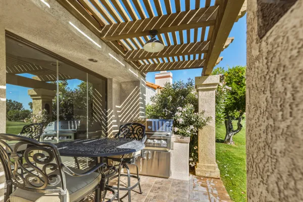 a patio with glass top table and chairs