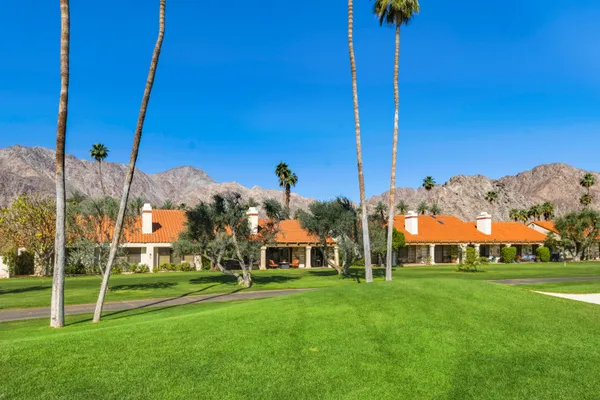 a backyard of a house with a garden and outdoor seating