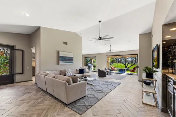 a living room with furniture a chandelier and a flat screen tv