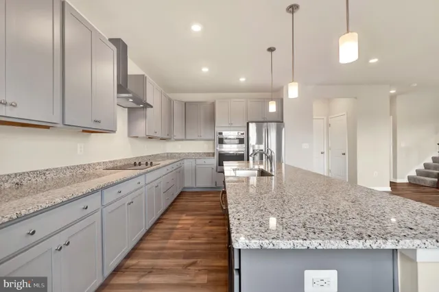a large kitchen with kitchen island a sink stainless steel appliances and cabinets