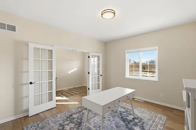 a view of a room with a window and wooden floor