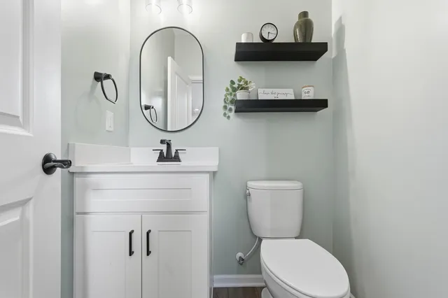 a bathroom with a toilet a sink and mirror