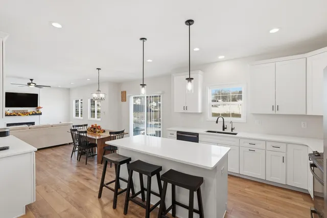 a view of a dining room and livingroom furniture wooden floor a rug and a chandelier