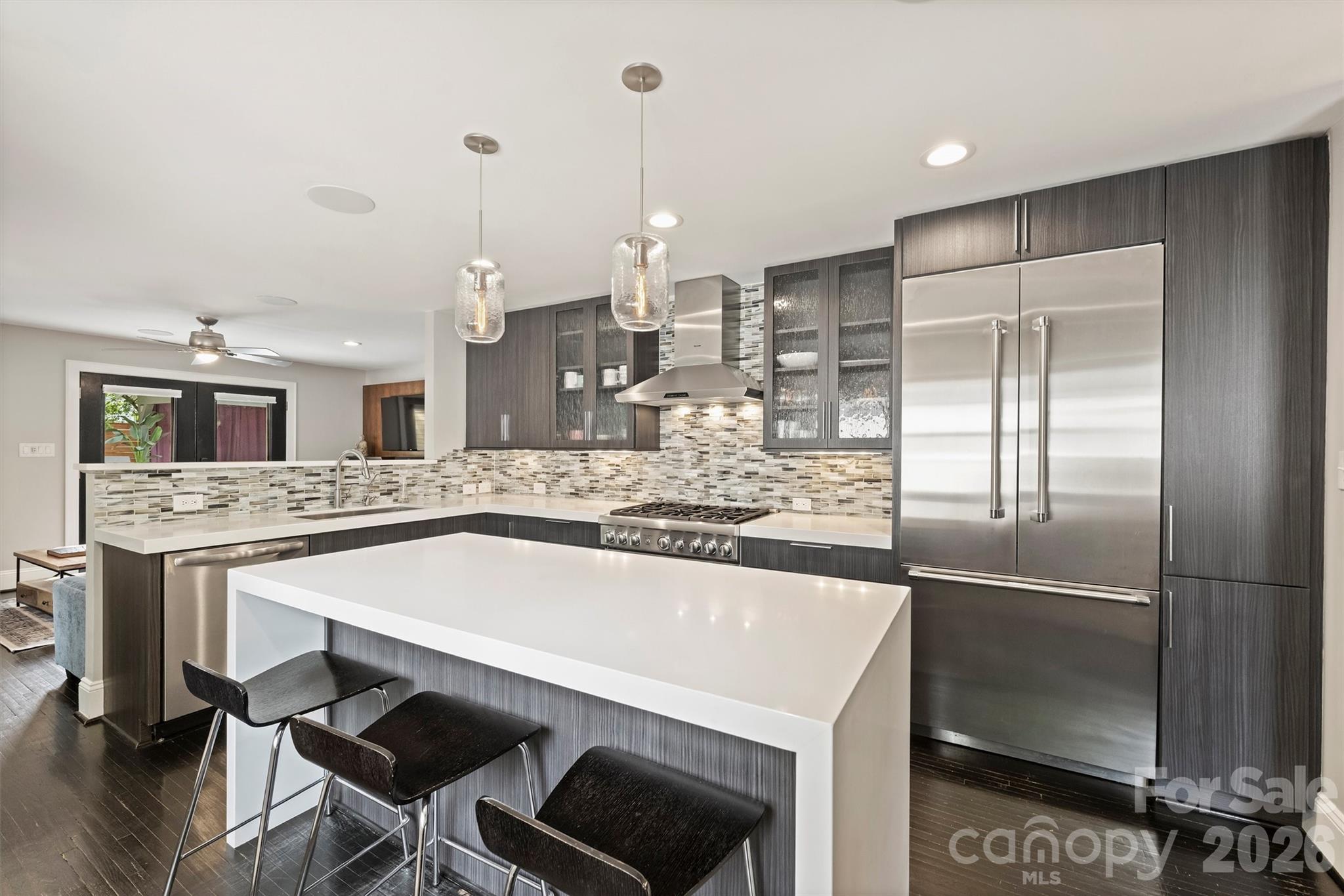 1734 Club Road Charlotte, NC 28205 - Photo 10 of 41 a kitchen with stainless steel appliances kitchen island a table chairs in it and wooden floors