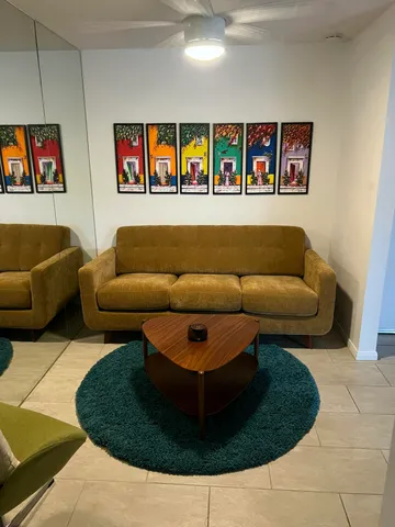 a living room with furniture and wall painting