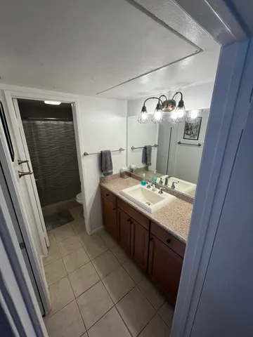 a bathroom with a double vanity sink toilet and shower