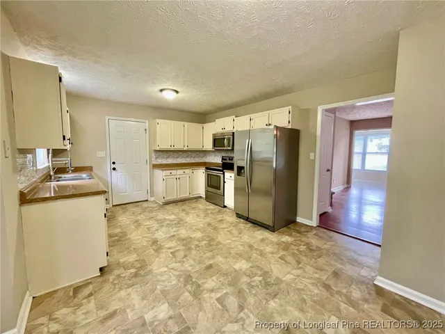 a kitchen with refrigerator and microwave