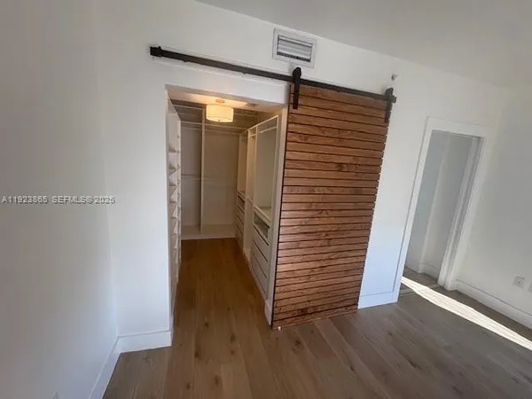 a view of a hallway with wooden floor and stairs