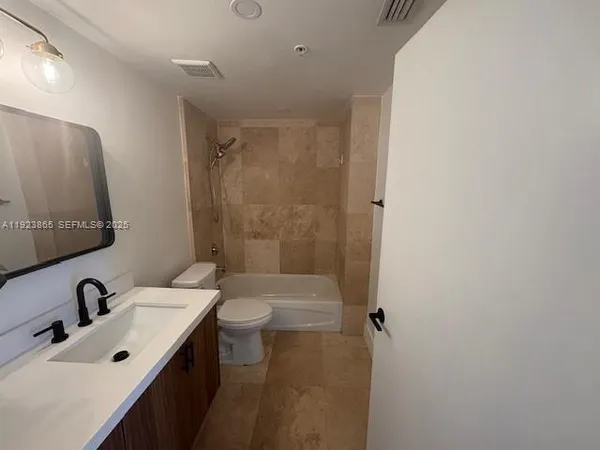 a bathroom with a sink mirror toilet and shower
