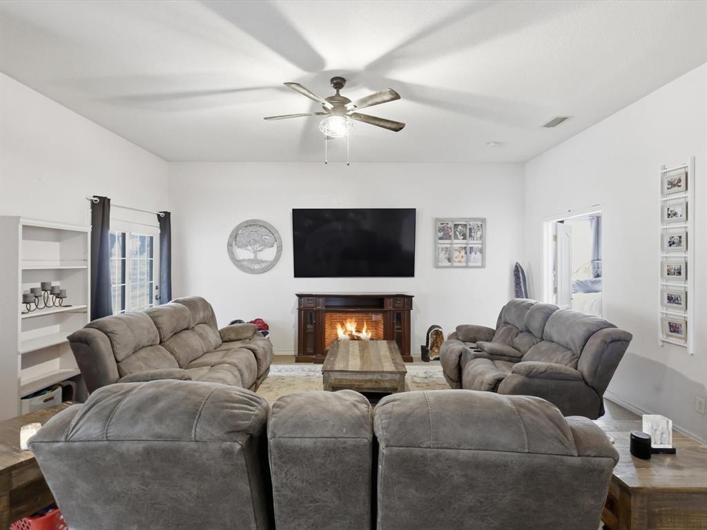 130 Parsonage Street Azle, TX 76020 - Photo 18 of 39 Living area featuring a lit fireplace and ceiling fan