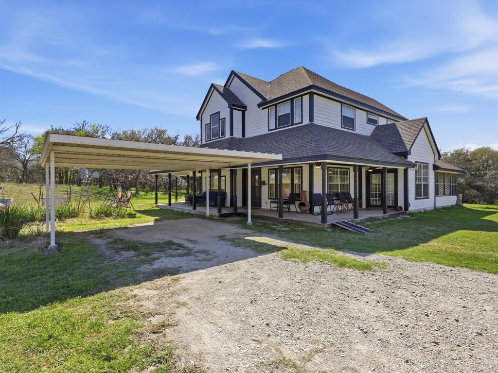 130 Parsonage Street Azle, TX 76020 - Photo 3 of 39 View of front of property featuring a front yard, a shingled roof, dirt driveway, a patio, and a carport