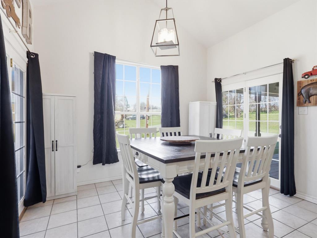 130 Parsonage Street Azle, TX 76020 - Photo 9 of 39 Dining area with light tile patterned flooring and vaulted ceiling