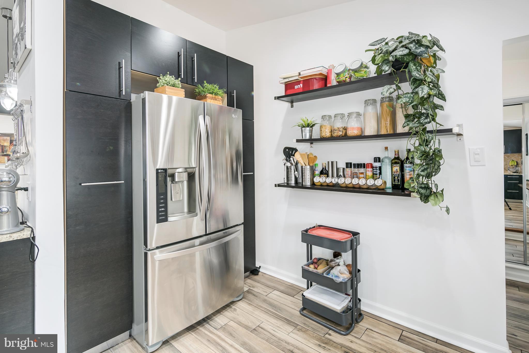 136 Claybrook Drive Silver Spring, MD 20902 - Photo 13 of 30 a kitchen with stainless steel appliances a refrigerator and a wooden floor