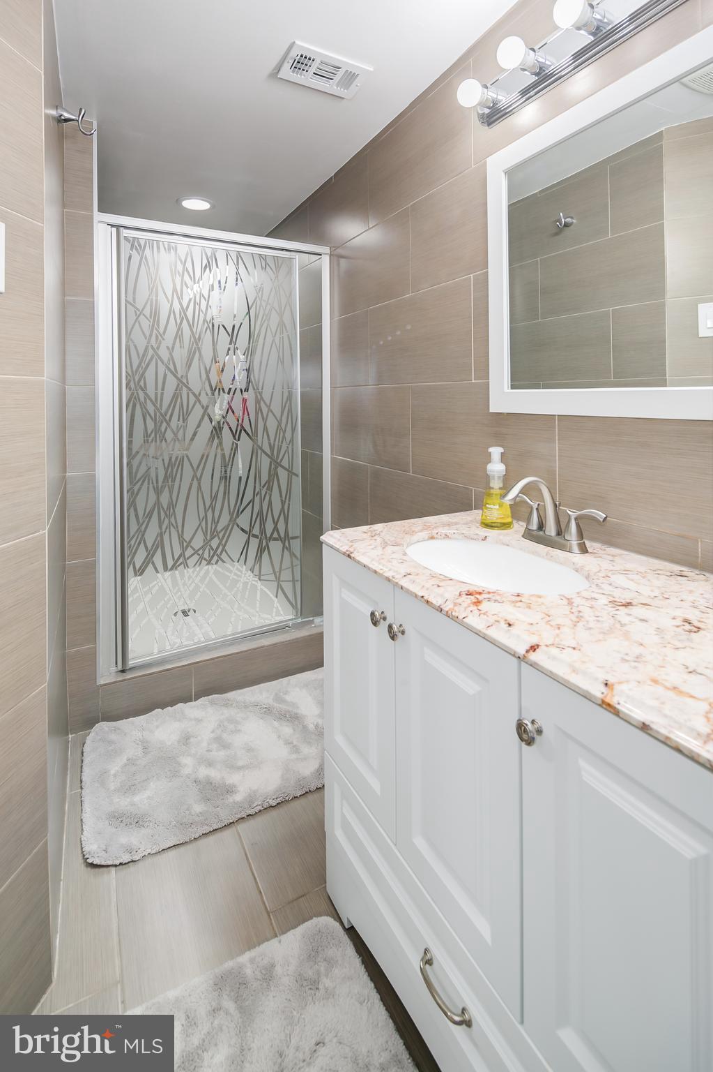 136 Claybrook Drive Silver Spring, MD 20902 - Photo 27 of 30 a bathroom with a granite countertop sink a mirror and shower