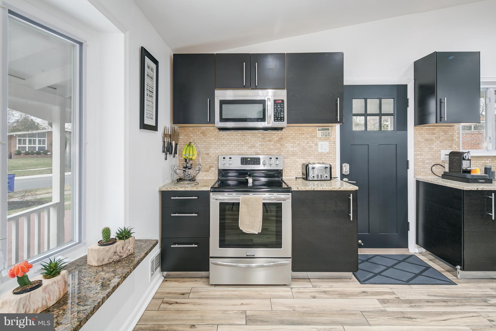 136 Claybrook Drive Silver Spring, MD 20902 - Photo 10 of 30 a kitchen with stainless steel appliances kitchen island granite countertop a refrigerator stove and oven