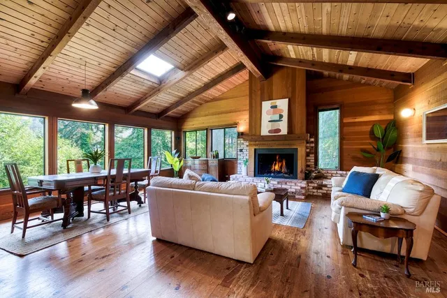 a living room with fireplace furniture and a large window