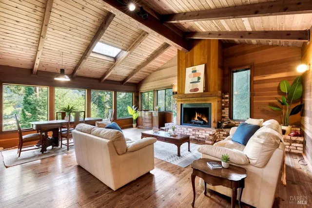 a living room with furniture a fireplace and a large window
