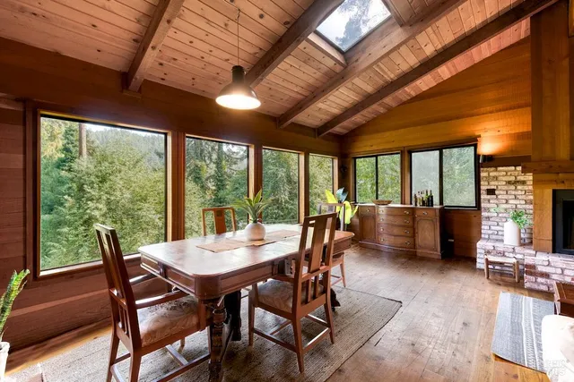 a view of a dining room with furniture large windows and wooden floor