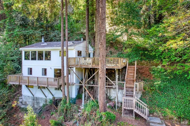 a aerial view of a house with balcony and trees all around