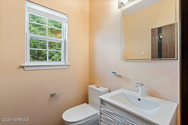 a bathroom with a sink a toilet and a mirror