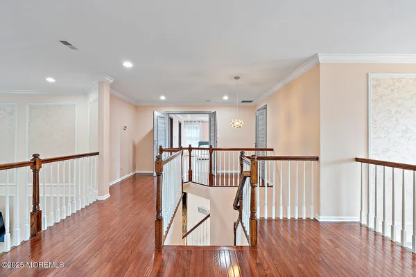 a view of a hallway with wooden floor and windows