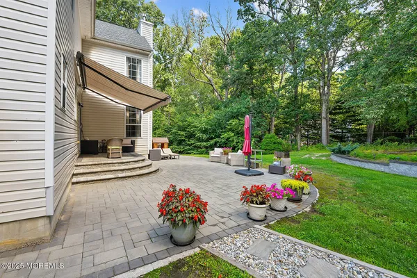 a view of a chair and tables in the back yard of the house