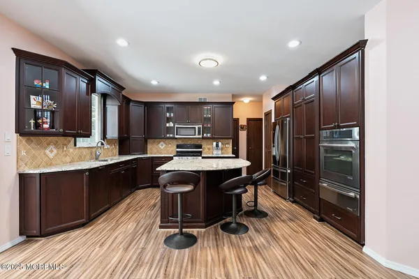 a kitchen with stainless steel appliances granite countertop a sink refrigerator and cabinets