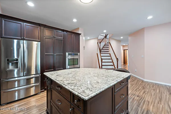 a kitchen with kitchen island a wooden floor and refrigerator