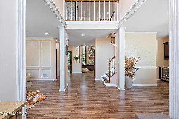a view of a hallway with wooden floor windows and a living room