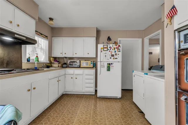 a kitchen with refrigerator and cabinets