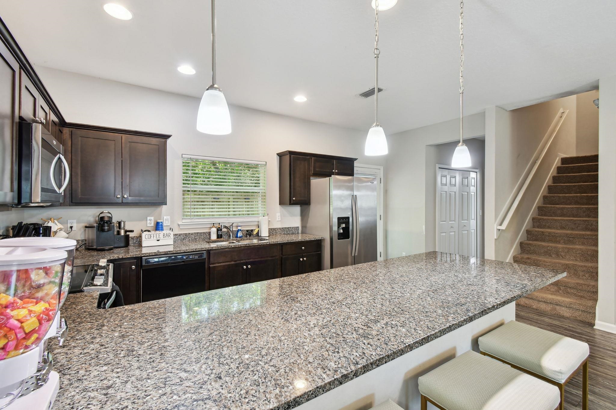241 Columbus Street St. Augustine, FL 32084 - Photo 11 of 47 a kitchen with stainless steel appliances granite countertop a sink refrigerator and cabinets