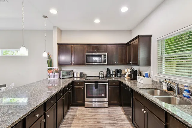 a kitchen with granite countertop sink stainless steel appliances and cabinets