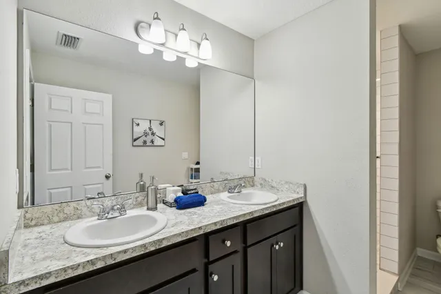 a bathroom with a granite countertop sink and a mirror