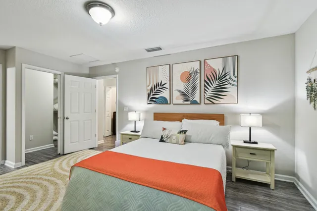 a bedroom with a large bed and a painting on the wall