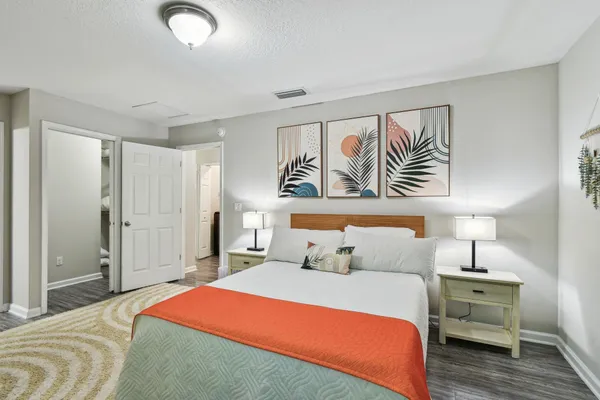 a bedroom with a large bed and a painting on the wall