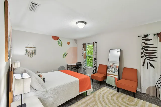 a bedroom with bed and a chair