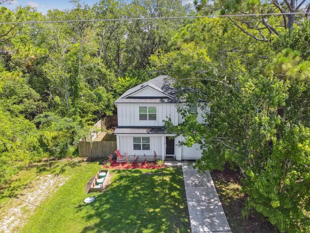 a view of a house with a yard and potted plants