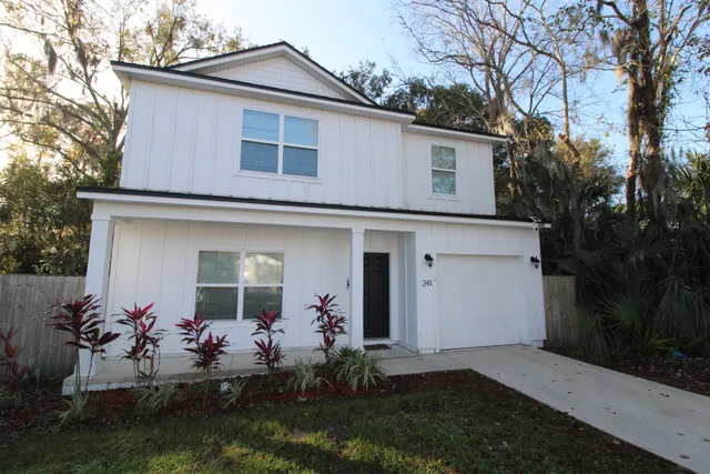 a front view of a house with a garden and plants
