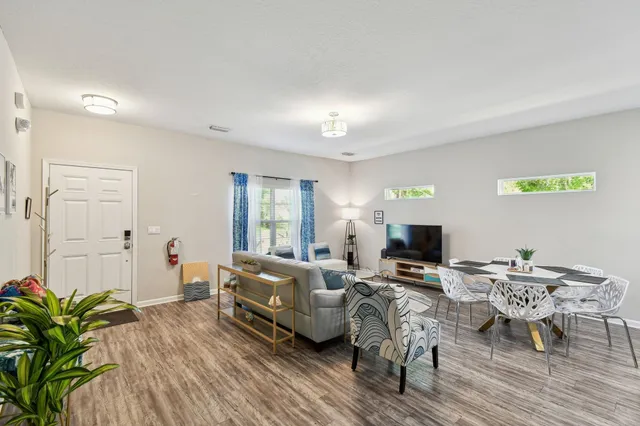 a living room with furniture and a wooden floor