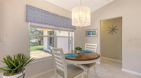 a dining room with furniture a chandelier and wooden floor