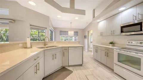 a view of a dining room with furniture a chandelier and a window