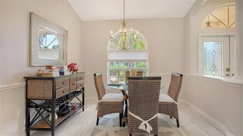 a bedroom with a large bed chandelier and a window