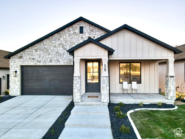 641 North Heritage Street, Unit 8 Mapleton, UT 84664 - Photo 5 of 34 View of front of home featuring a garage, board and batten siding, stone siding, concrete driveway, and covered porch